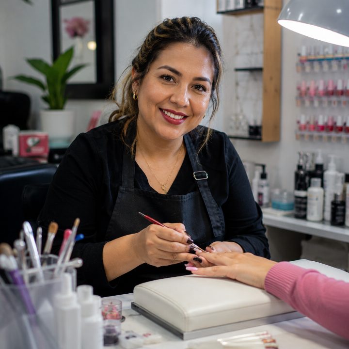 Manicurista trabajando con una clienta